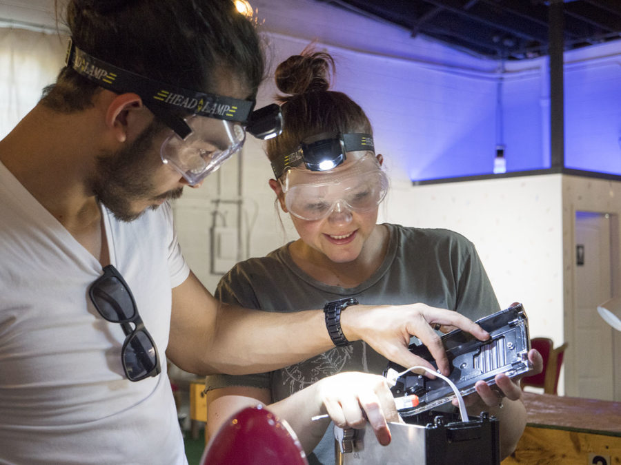 A couple takes apart a machine at CHAOS - photo by Dennis Spielma